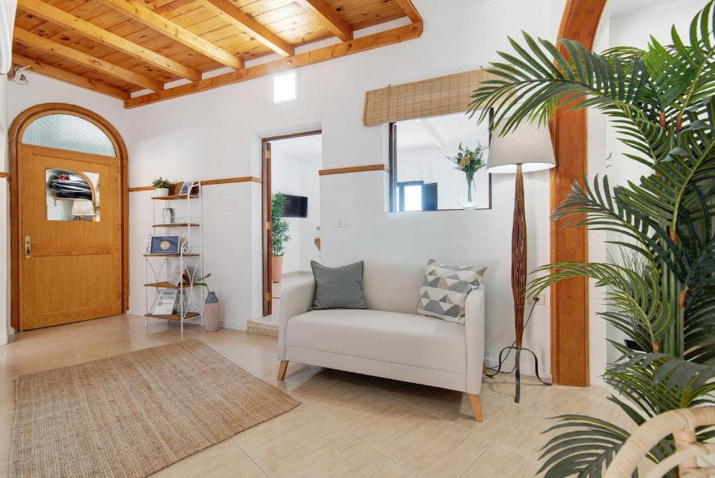 摩亚El Altillo House的客厅配有白色椅子和植物