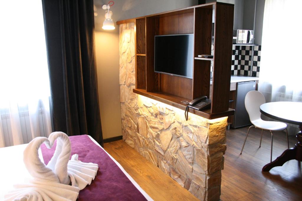 基希讷乌Aparthotel的酒店的客房配有电视和带毛巾的床。