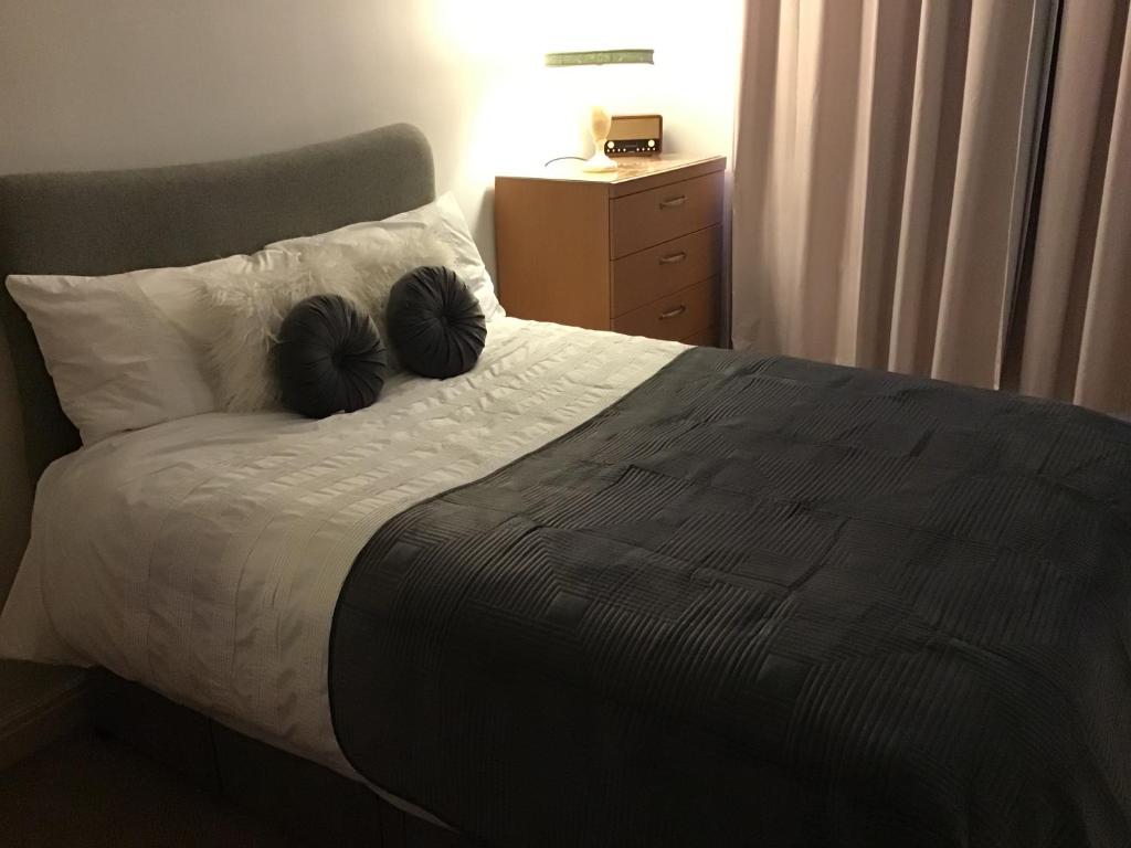莫顿Dovedale Apartment的一间卧室配有一张床铺,上面有两张黑色的密床