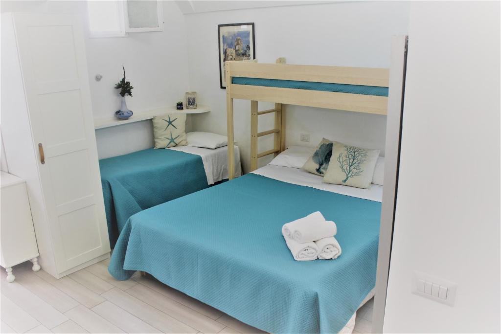 阿纳卡普里La Maiolica的一间卧室配有两张床和一张双层床及毛巾