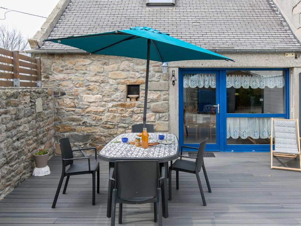 桑泰克Holiday Home Ty Kerveal - TEC210 by Interhome的甲板上配有桌椅和遮阳伞