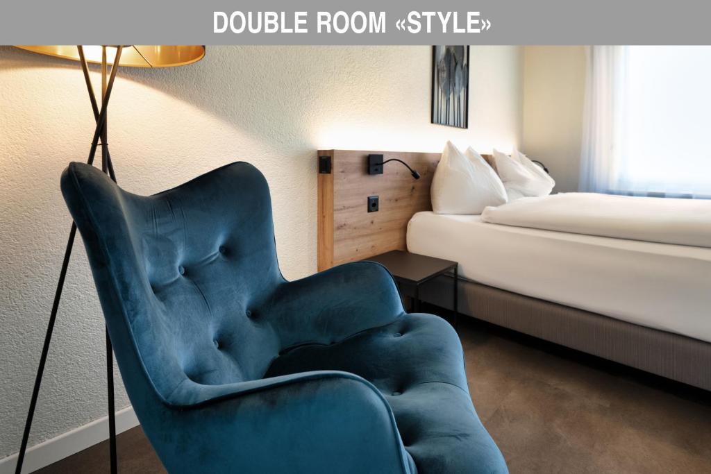 阿劳巴朗苏尔酒店的一张蓝色椅子,位于酒店带床的房间里