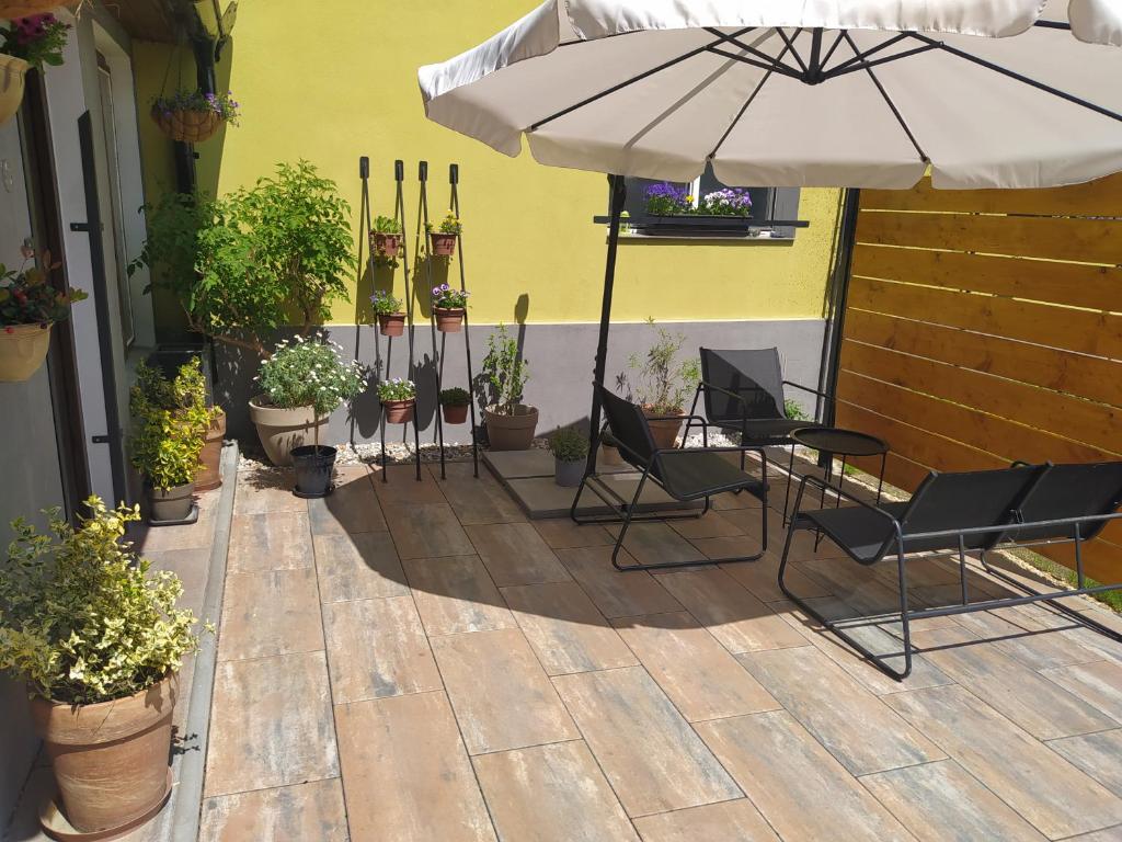 特热邦Ubytování Pohoda的庭院设有椅子、雨伞和盆栽植物