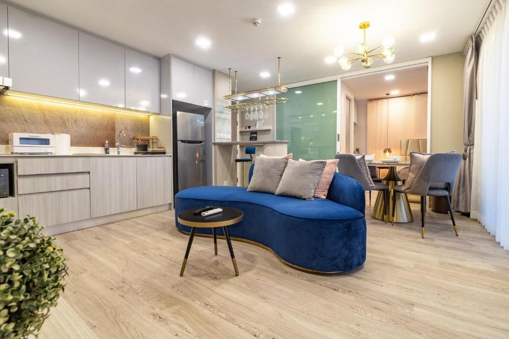 华欣Huahin Stay的一间带蓝色沙发的客厅和一间厨房