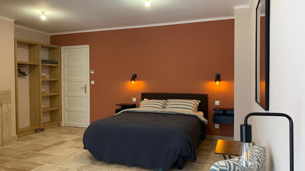 比兹米内瓦Logis de la Foulerie的一间卧室配有橙色墙壁的床