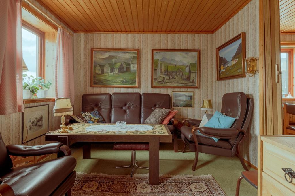 3-Bedroom Home in Eiði的客厅配有沙发和桌椅