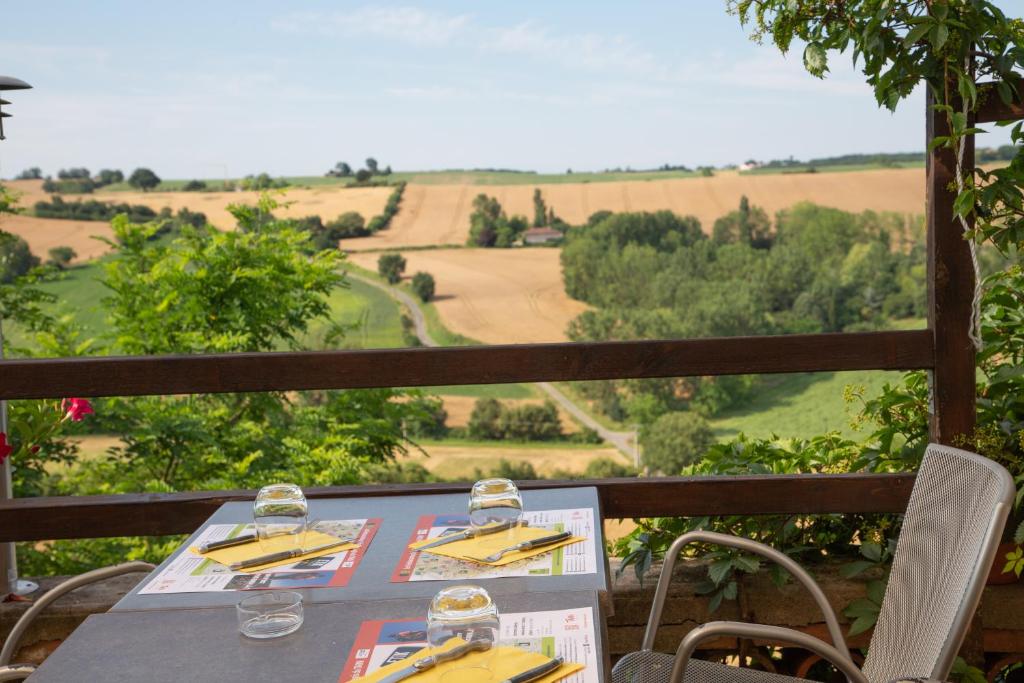 SalvagnacLogis - Le relais des deux vallées的一张桌子,上面放有酒杯,享有美景