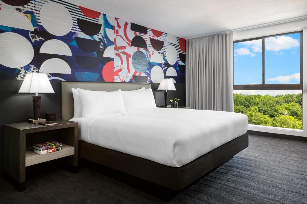 波士顿波士顿奥尔斯顿到一室公寓酒店的酒店客房设有床和色彩缤纷的墙壁。