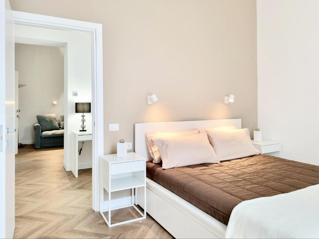 卡利亚里Glamour Suite Cagliari的白色卧室配有床和镜子