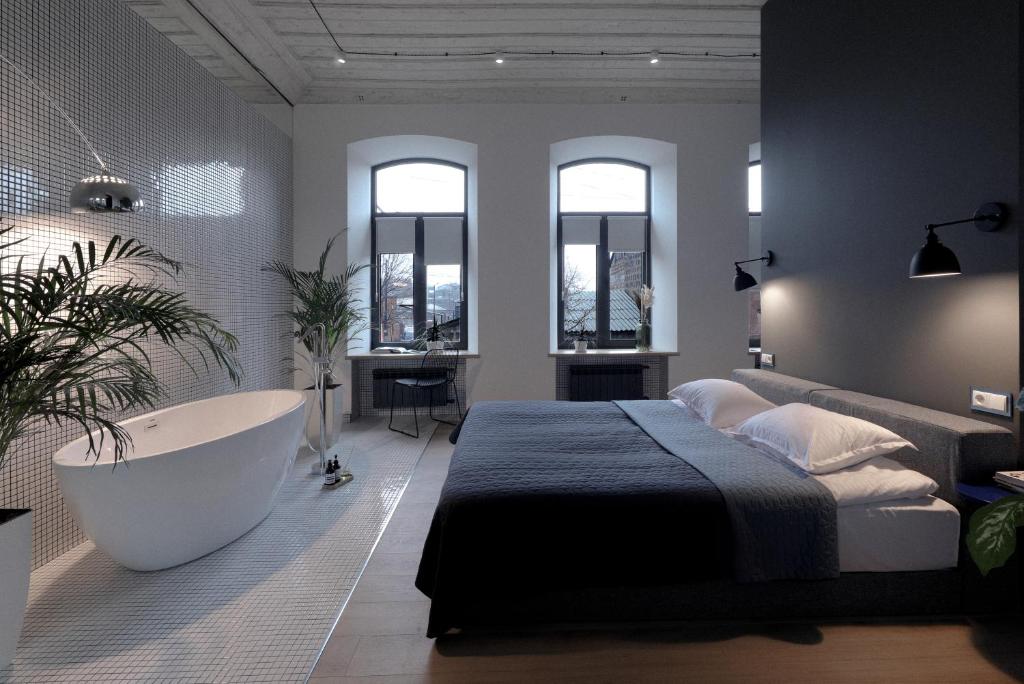久姆里Major's House Gyumri的一间卧室配有一张床、浴缸和窗户。