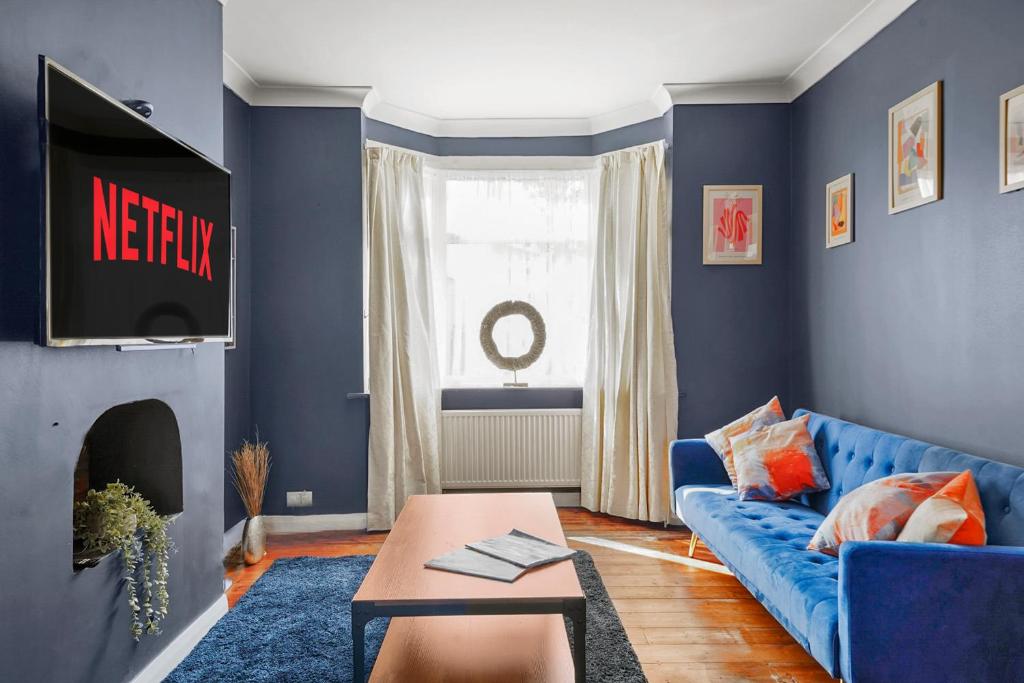 达特福德Home at The Brent的客厅拥有蓝色的墙壁和蓝色的沙发