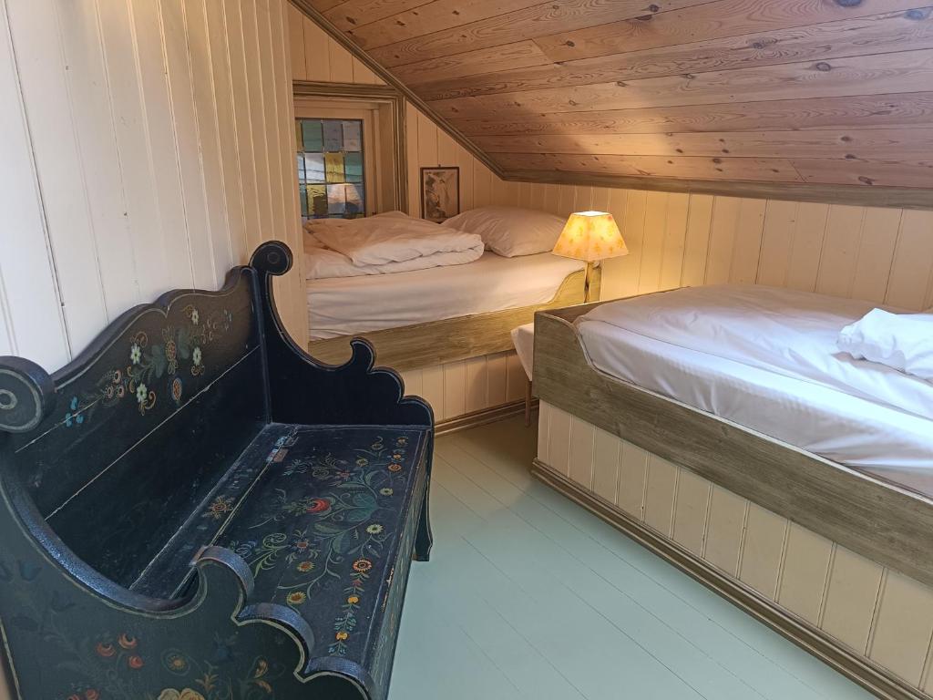 OrheimOrheimstunet - Gårdsferie for storfamilien der også hunden er velkommen的一间卧室配有两张床,房间设有长凳