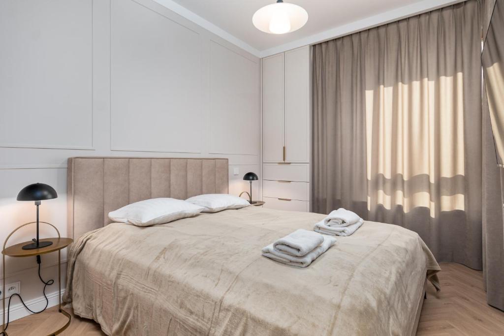 华沙Aleja Solidarności 60B (B) by Homeprime的白色卧室配有一张大床和毛巾