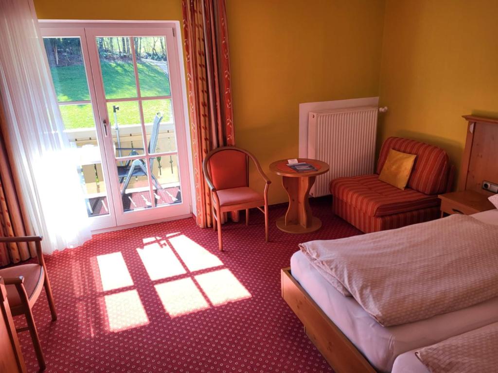 基姆湖畔普林Gästehaus Schwarz的一间卧室配有一张床、一张桌子和一个窗户。
