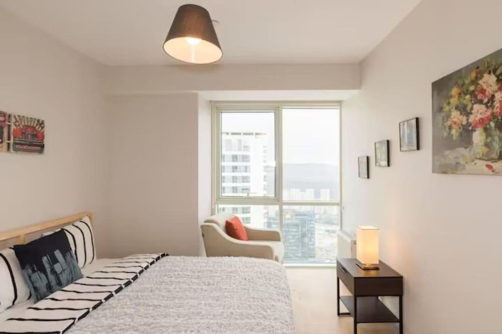伊斯坦布尔Residence 5 etoiles Orya Park avec piscine的卧室配有床、椅子和窗户。