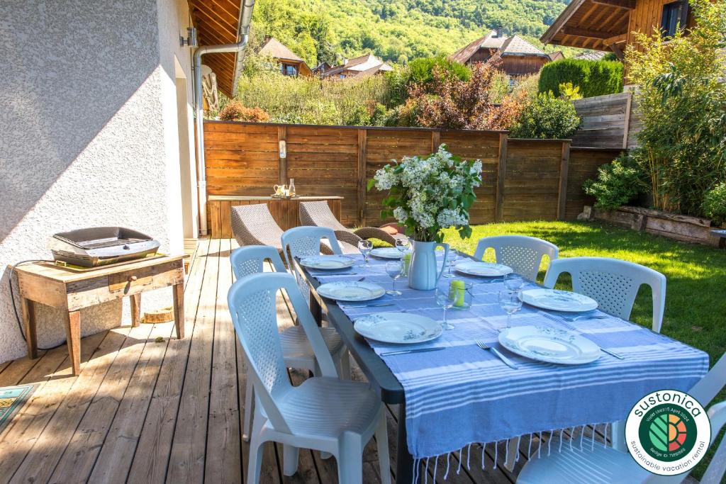 La PirrazSous le soleil de Lanfon - Maison au Calme avec jardin clos, LLA Selections by Location Lac Annecy的天井上一张带蓝色桌布的桌子