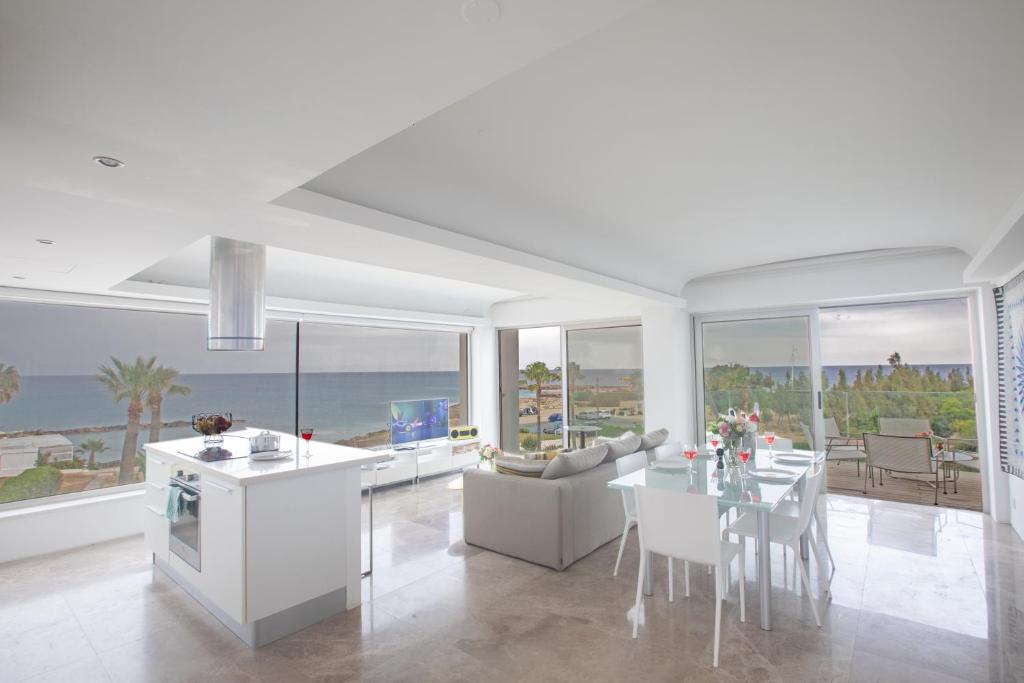 普罗塔拉斯Thalassa Luxury Apartment的厨房以及带桌椅的起居室。