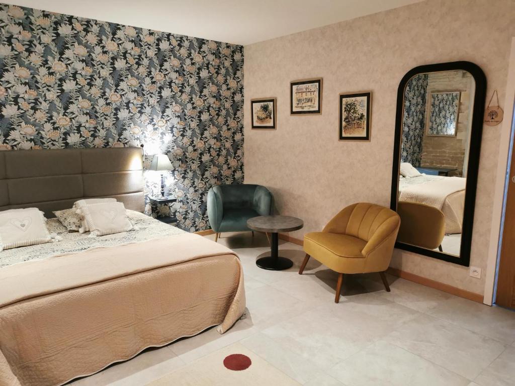 Sainte-Croix-sur-MerChambre de l'Iris的一间卧室配有一张床、镜子和椅子