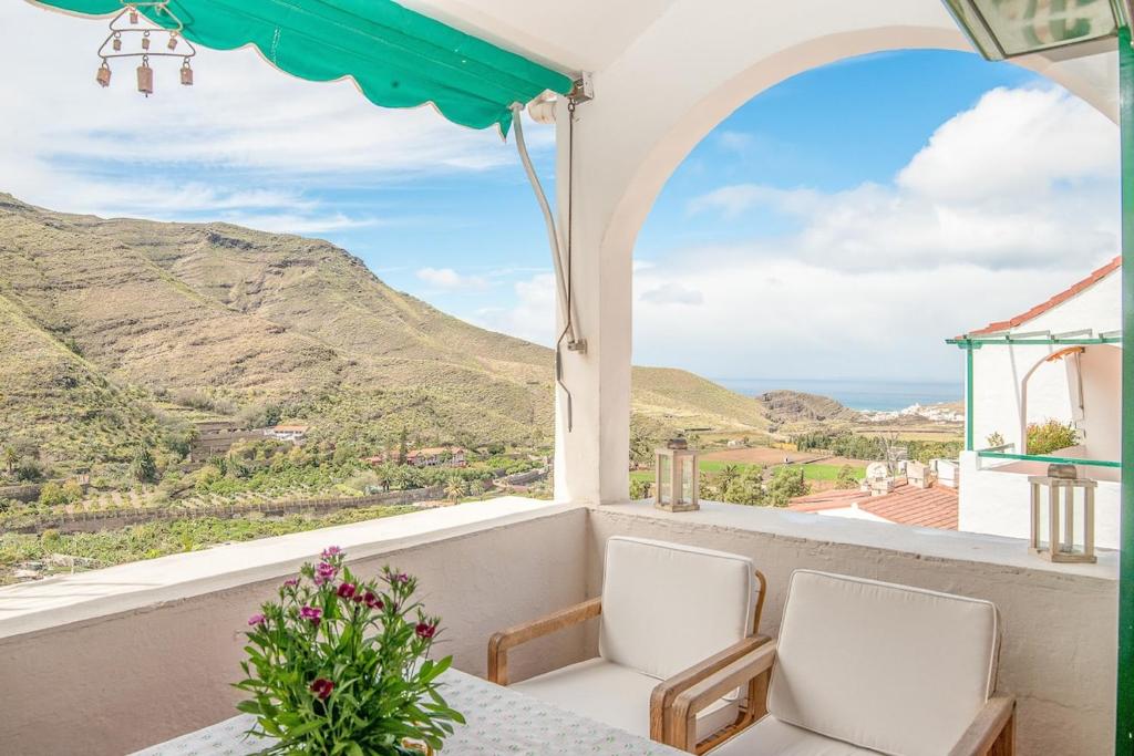 阿格特Casa Carmen Agaete Vista al Mar的阳台配有桌椅,享有山景。