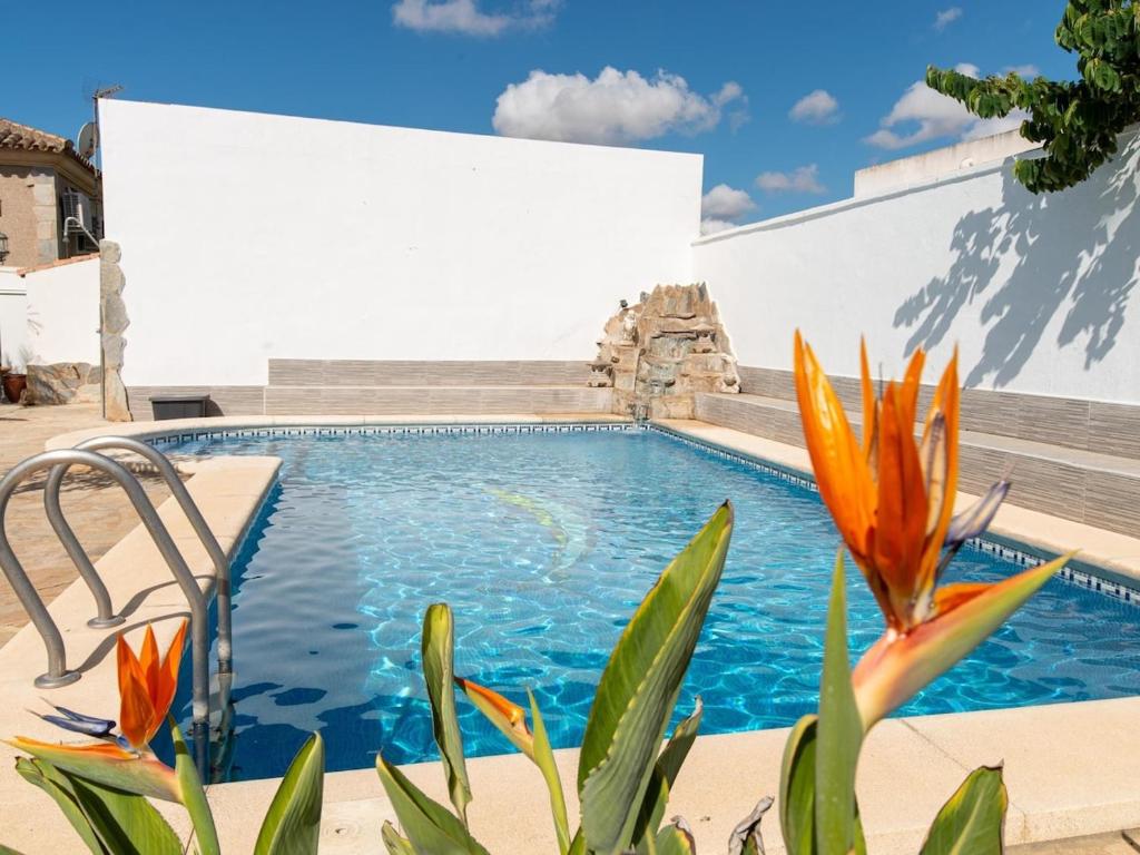 圣玛丽亚港Lightbooking Blanca Paloma Cádiz的一座种植了橘子花的游泳池,位于一座建筑前