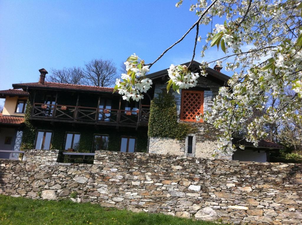 韦尔巴尼亚Il Ciliegio Selvatico的一座石墙和花卉树的房子
