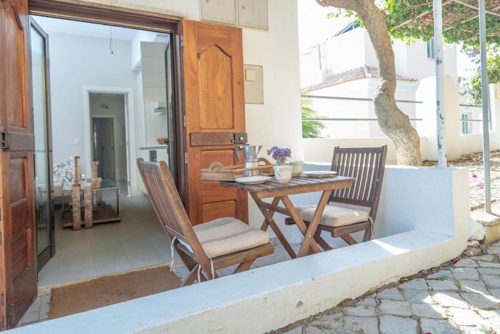 维拉诺瓦德卡塞拉Lightbooking Praia Fabrica Algarve的庭院配有木桌和两把椅子