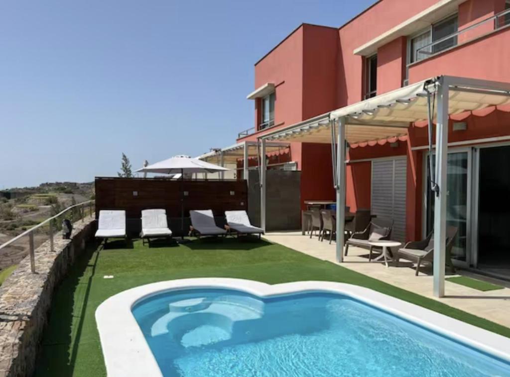 圣巴托洛梅Lightbooking piscina privada Salobre Golf的一个带游泳池和房子的后院