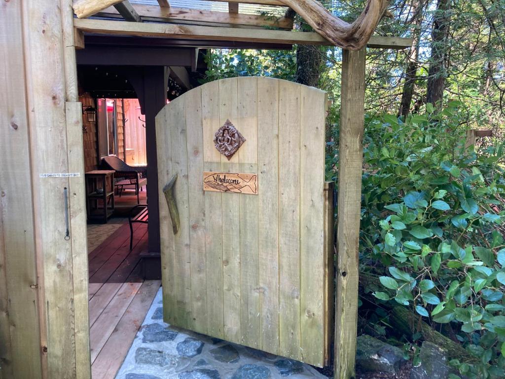 尤克卢利特Forest Sweet Retreat Hot Tub & Wood Fired Sauna的花园内有木门,上面有标志