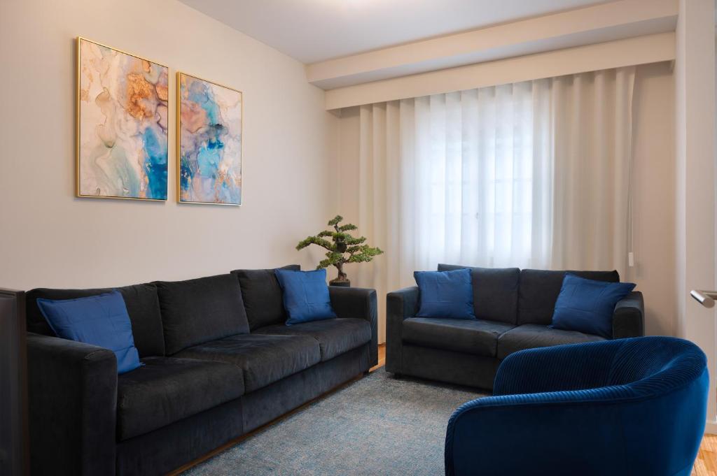 波尔图Invicta Premium - Downtown apartment的客厅配有沙发和两把椅子