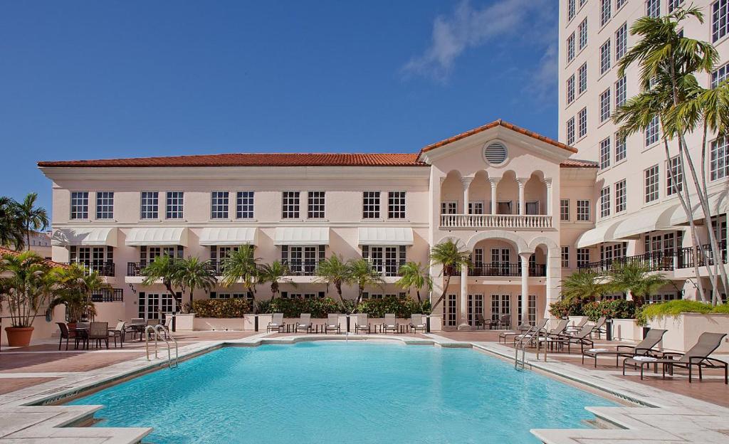 迈阿密科勒尔盖布尔斯凯悦酒店，​​迈阿密的一座大型建筑,在一座建筑前设有一个游泳池