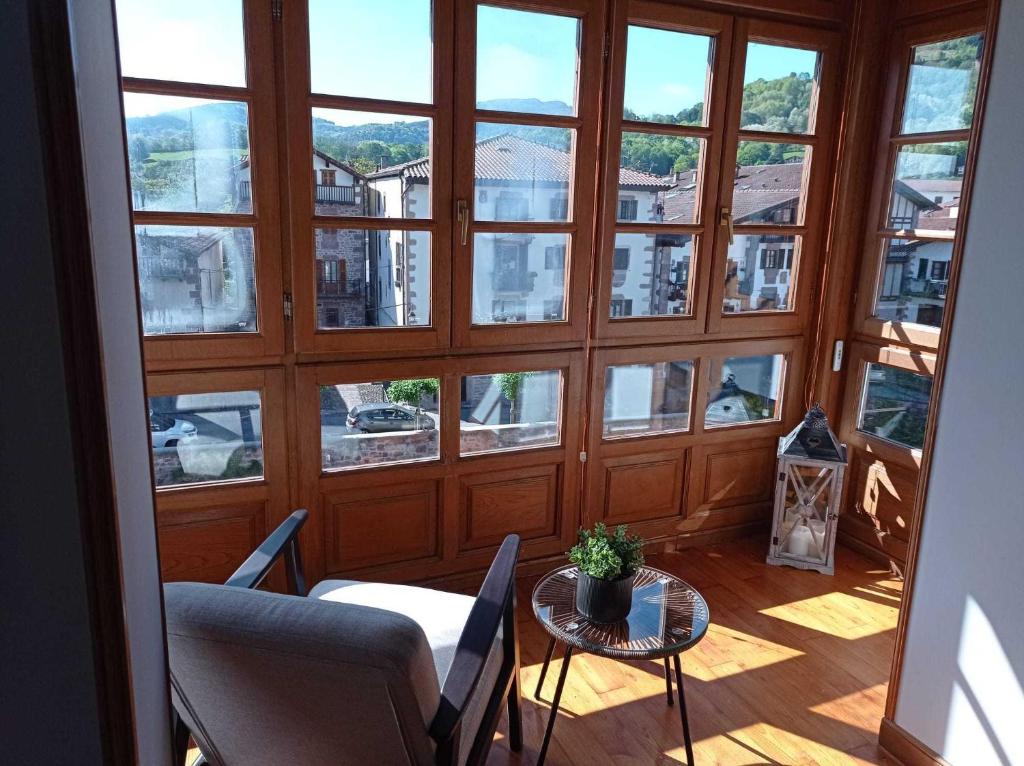 埃利松多Arotzetxea的客房设有带桌椅的大窗户。