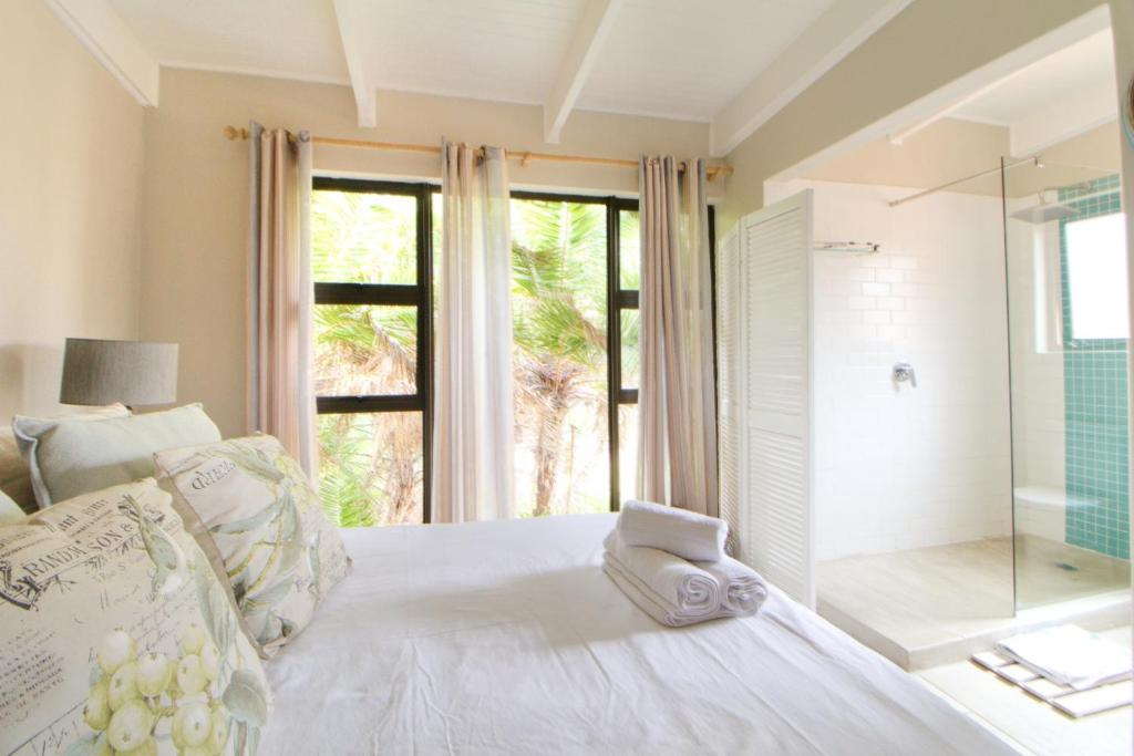 绍斯布鲁姆San Lameer Villa 3407 by Top Destinations Rentals的卧室配有白色的床和玻璃淋浴间