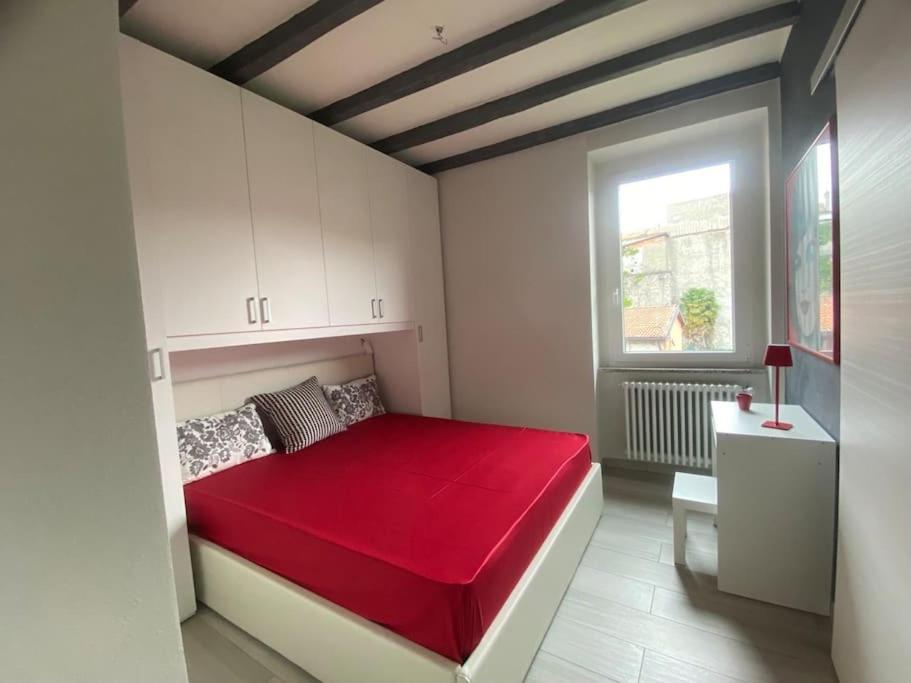 科莫Marilyn Apartment的一间卧室设有红色的床和窗户。