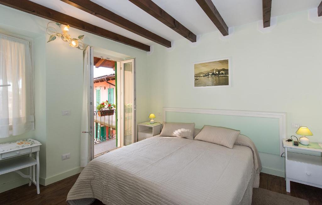 巴韦诺B&B Casa del Lago的白色的卧室设有床和窗户