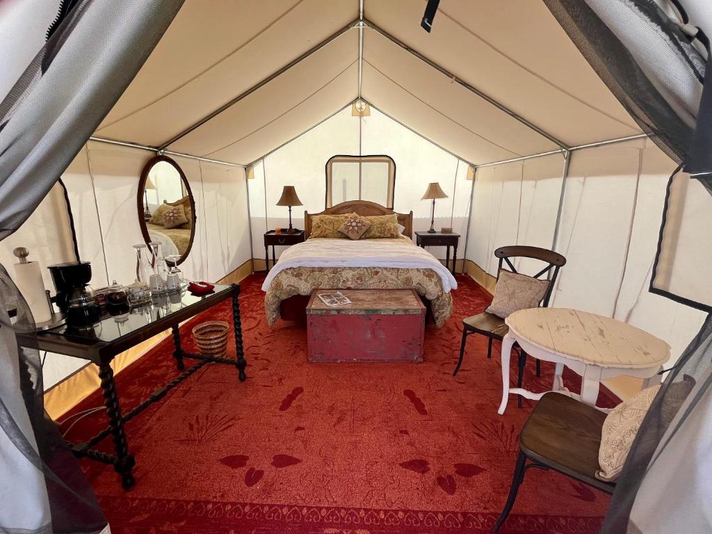 PaoniaCosmo Glamping Tent at Zenzen Gardens的帐篷内一间卧室,配有一张床