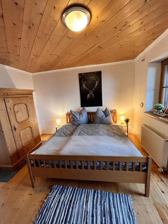 NiederndorferbergFerienhaus Praschberg的一间卧室设有一张带木制天花板的大床