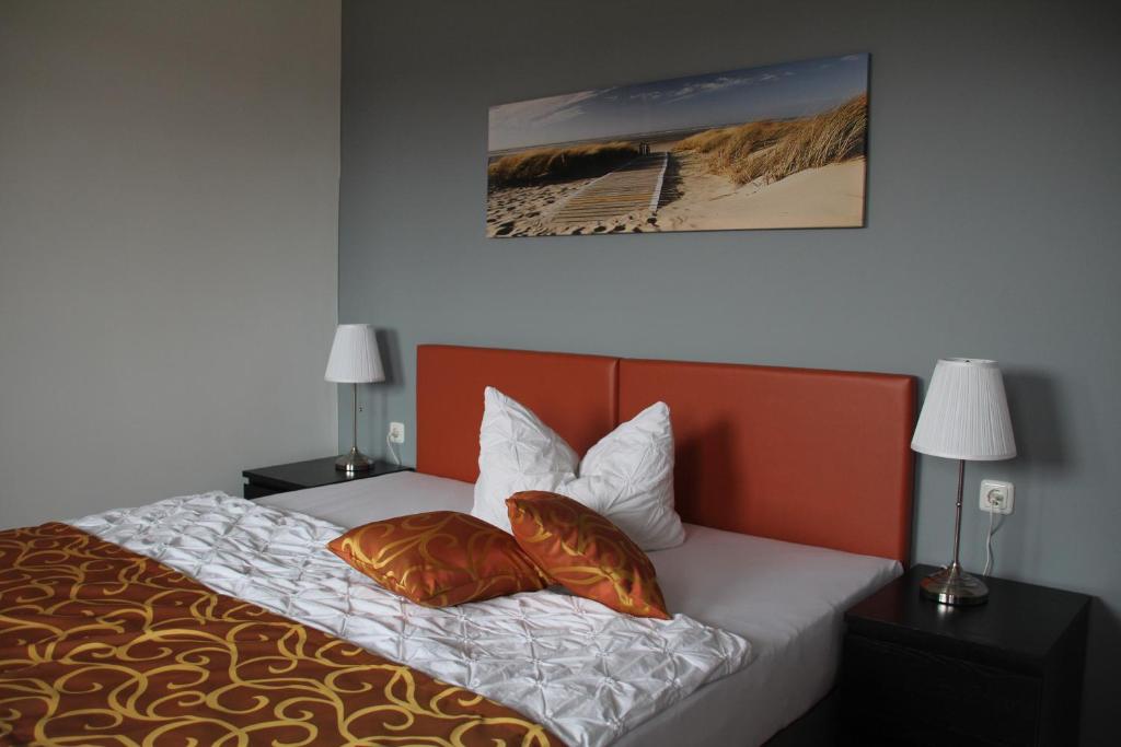 罗斯托克安特威戈公寓的一间卧室配有一张带两个枕头的床