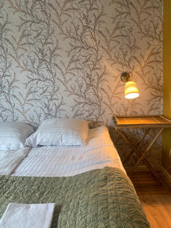 察姆GÆSTEHUSET的一间卧室配有一张床和一张带台灯的桌子