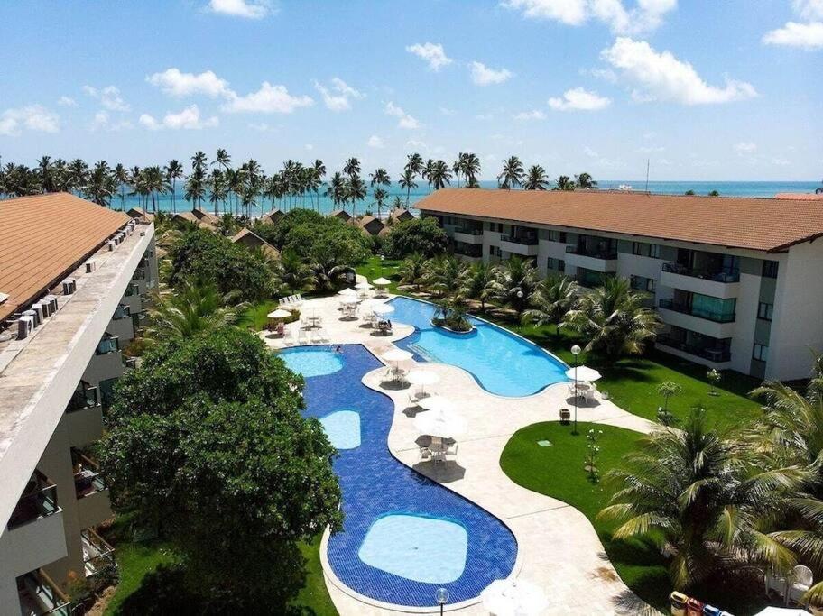 塔曼达雷Flat Beira Mar - Carneiros Beach Resort的享有带游泳池的度假村的空中景致