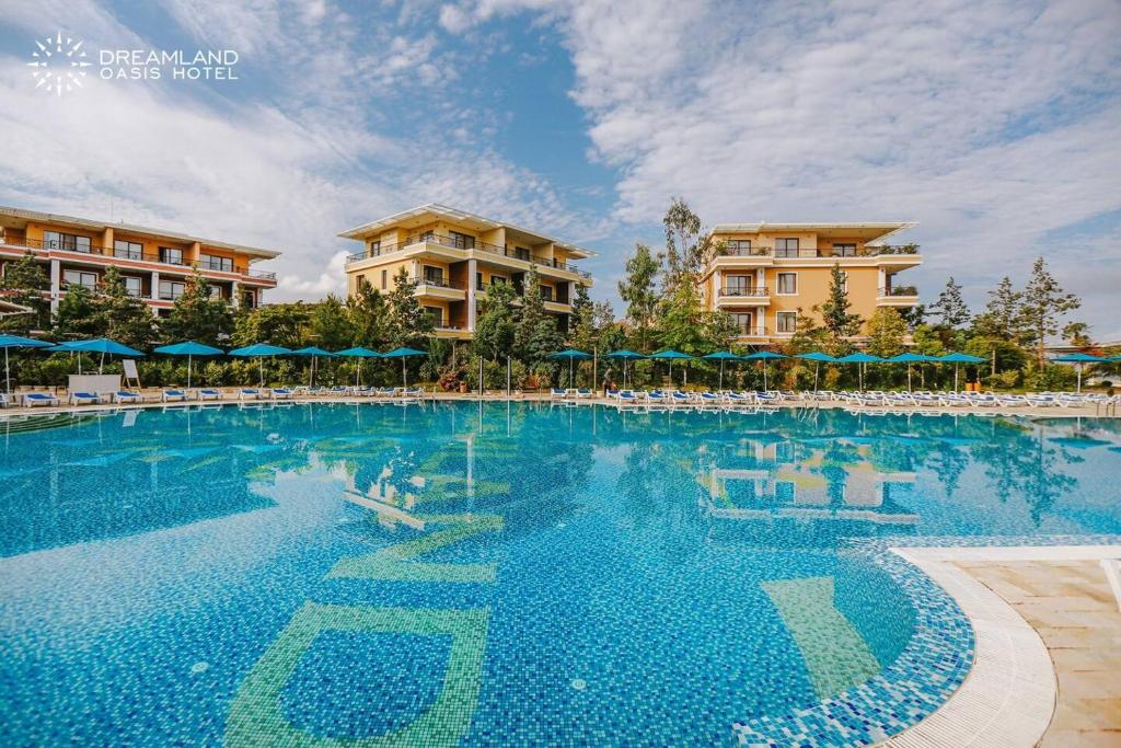 查克维Dreamland Oasis luxury apartment的度假村的游泳池,配有椅子和遮阳伞