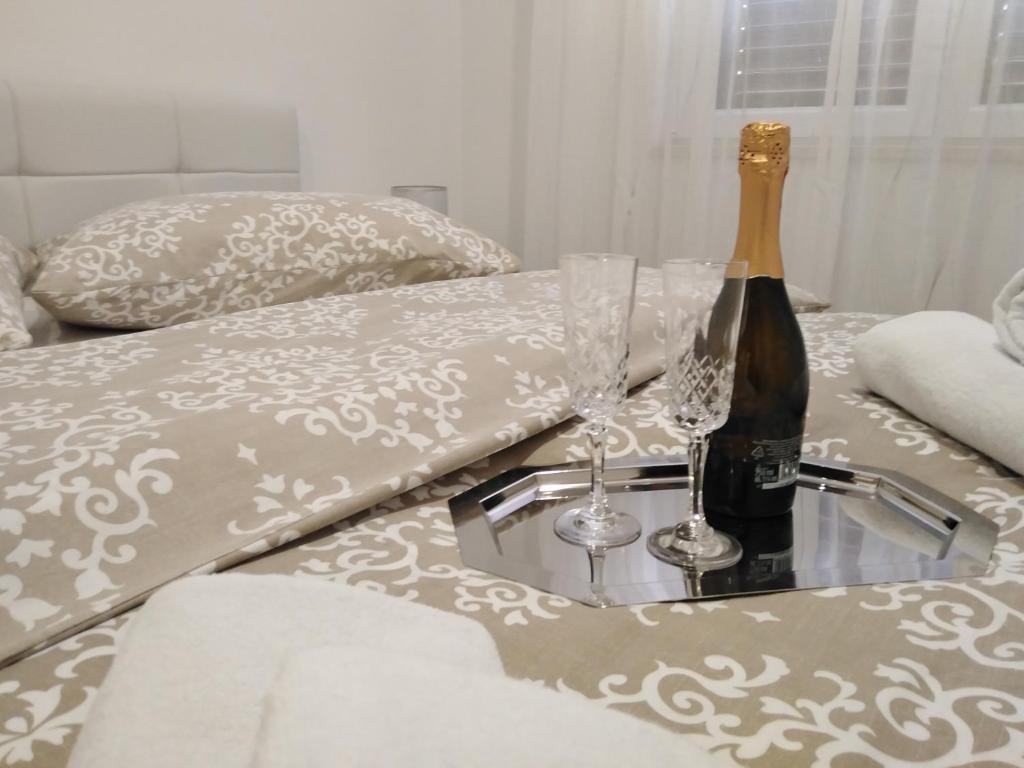 普洛切Apartman Roko的床上的一瓶香槟和两杯酒