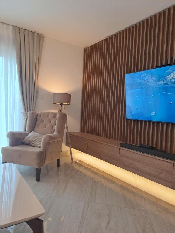 蒂瓦特Lux Apartment Jovanovic的客厅配有椅子和墙上的电视