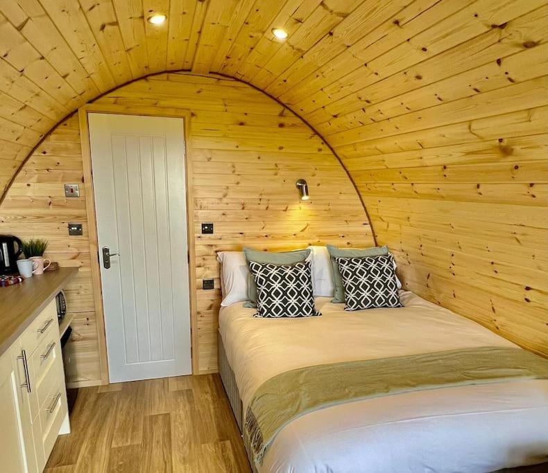 斯莱戈Plumgrove Pod Easkey的木制客房内的一间卧室,配有一张床