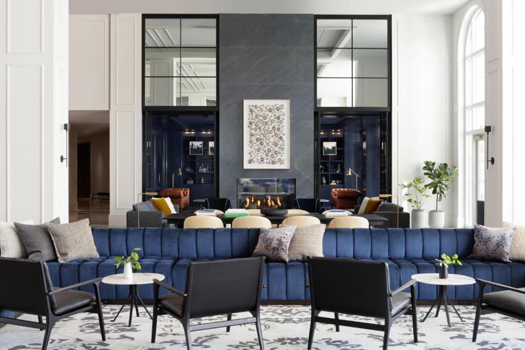 夏洛茨维尔Kimpton - The Forum Hotel, an IHG Hotel的客厅配有蓝色的沙发和椅子