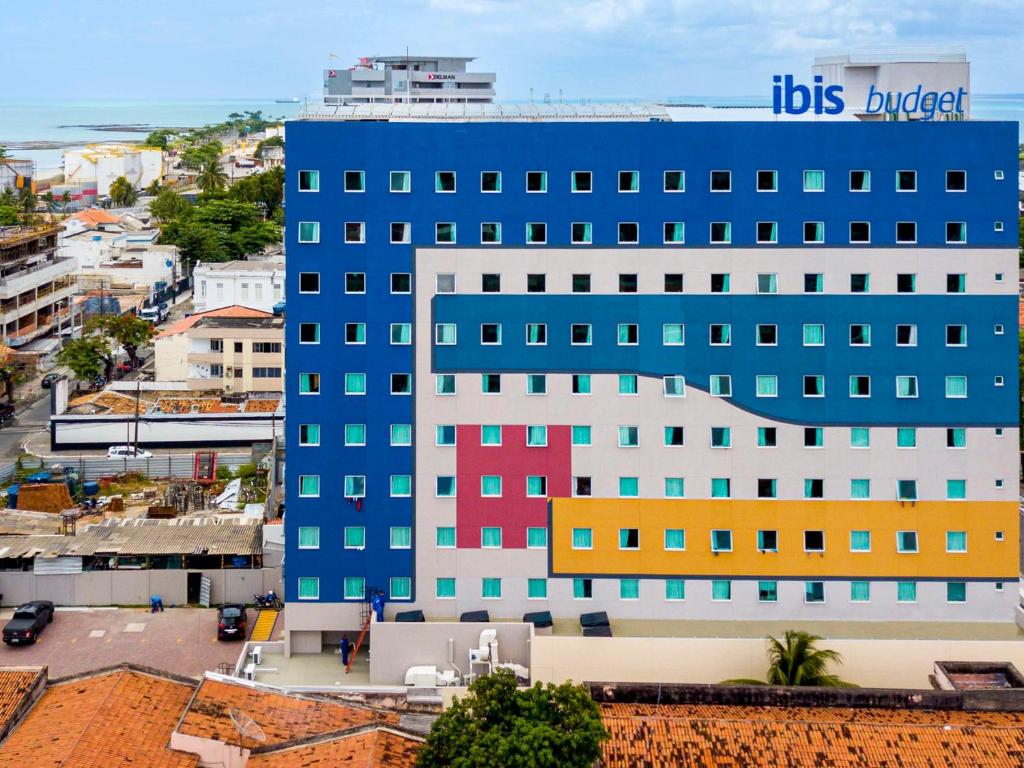马塞约ibis budget Maceió Pajuçara的一座大型蓝色建筑,拥有色彩缤纷的窗户