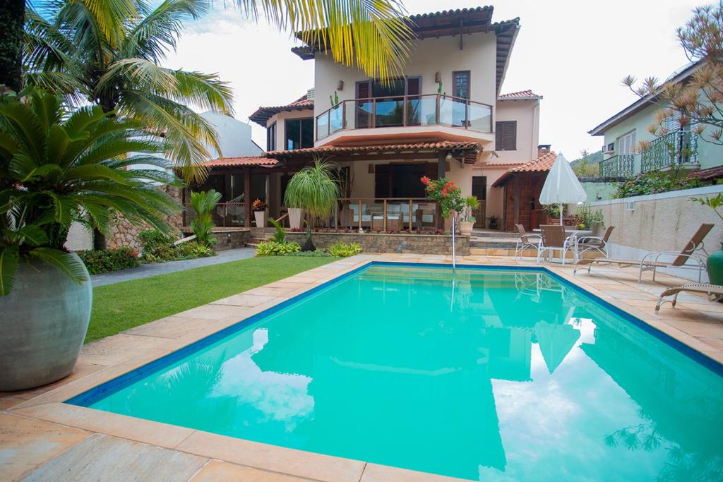 尼泰罗伊Casa a 50m da Praia de Itacoatiara Niteroi RJ的房屋前的游泳池