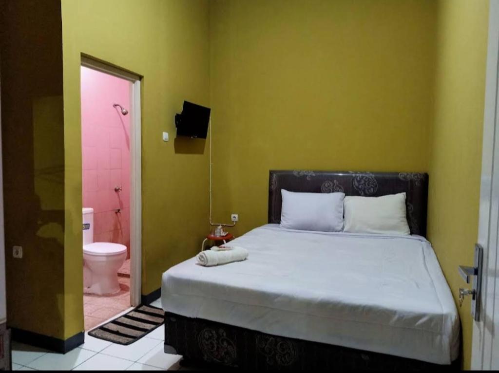 井里汶PONDOK CHILLY的一间卧室配有一张床,浴室设有卫生间