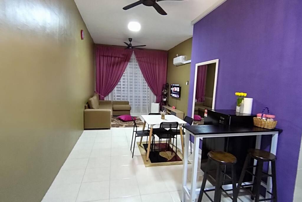 ChemorCASA Singgah Homestay的客厅设有紫色墙壁和桌椅