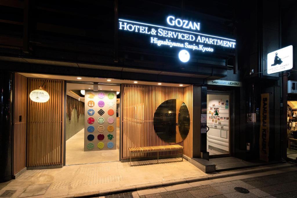 京都GOZAN HOTEL & SERVICED APARTMENT Higashiyama Sanjo的一家酒店前面的商店,上面有标志