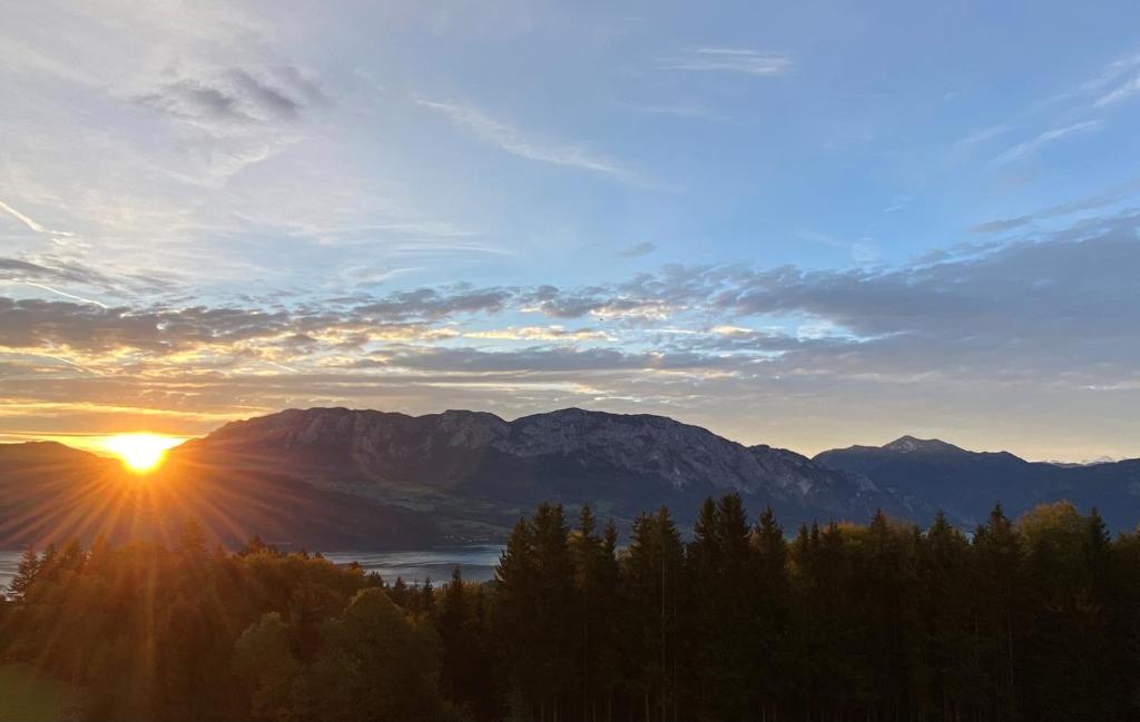 阿特湖畔努斯多夫Appartmens am Attersee Dachsteinblick的享有山脉日落美景